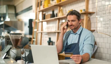 männlicher Barista macht eine Online-Bestellung mit einer Business Zusatzkarte