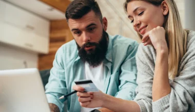 junges Paar mit Platinum Kreditkarte beim Online-Shopping